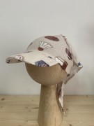 Lekka i przewiewna – muślinowa chusta dziecięca w piłki. Beżowe tło i sportowy wzór to połączenie, które pokochają mali fani aktywności.