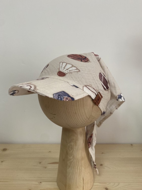 Lekka i przewiewna – muślinowa chusta dziecięca w piłki. Beżowe tło i sportowy wzór to połączenie, które pokochają mali fani aktywności.