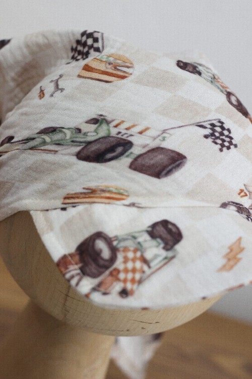 Zbliżenie na detal tkaniny – kaski, narzędzia, auta i kratka.