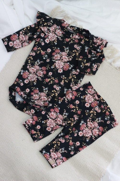 Zestaw prezentowy Midnight Bloom dla dziewczynki – body z falbankami i legginsy w elegancki, kwiatowy wzór. Całość zapakowana w stylowe pudełko z okienkiem, idealne na baby shower lub urodziny.