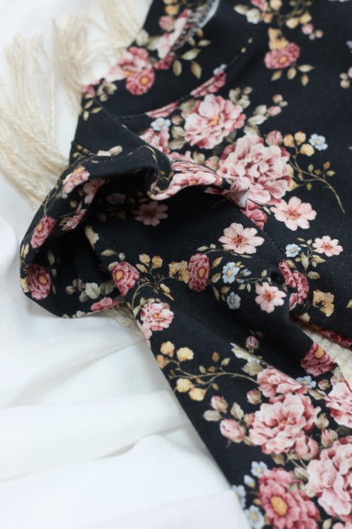 Detal falbanek przy body z kolekcji Midnight Bloom – dwustronne, starannie uszyte, pięknie eksponują kwiatowy wzór z każdej strony. Dziewczęcy akcent pełen uroku.