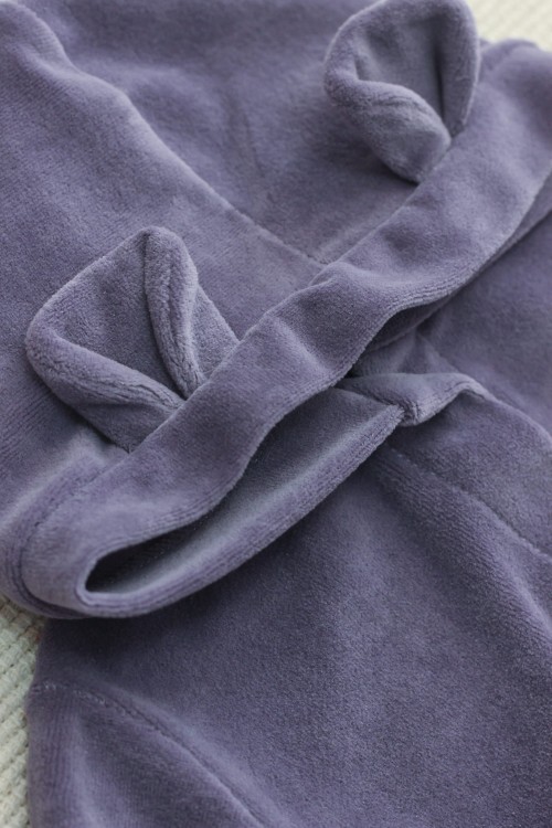 Detal, który zachwyca – kaptur ozdobiony uroczymi uszkami misia, dodającymi kombinezonowi wyjątkowego charakteru.